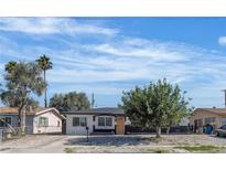 Charming single-story home with a well-maintained front yard and mature trees under a blue sky at 417 Freeman Ave, Las Vegas, NV 89106