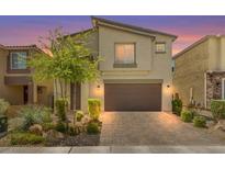 Two-story home with a landscaped front yard, brick driveway, and attached two-car garage at 4511 Stardusk Falls Ave, North Las Vegas, NV 89084