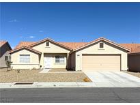 Charming single-story home featuring a terracotta tile roof, two-car garage and low-maintenance desert landscaping at 4618 Zia Ridge St, North Las Vegas, NV 89031