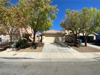 Charming home featuring a well-manicured lawn, mature trees and a two-car garage at 5474 Jacobs Field St, Las Vegas, NV 89148