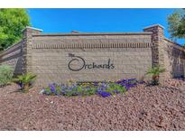 Stone sign at The Orchards community entrance with colorful flower beds and landscaping at 7380 Abundant Harvest Ave, Las Vegas, NV 89131
