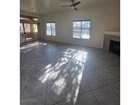 Bright living room featuring tile floors, large windows, and a cozy fireplace, perfect for comfortable living at 8985 S Durango Dr # 1154, Las Vegas, NV 89113