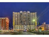 A vibrant night view of a high-rise building complex in a bustling urban setting with a distinctive architectural design at 150 Las Vegas Blvd # 1912, Las Vegas, NV 89101
