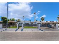 Charming single-story home featuring a modern fence, well-manicured lawn, and view of the Stratosphere tower at 2200 Santa Ynez Dr, Las Vegas, NV 89104
