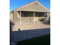 View of covered patio with brick pavers, privacy door, and outdoor grill at 3443 Citruscedar Way, North Las Vegas, NV 89032