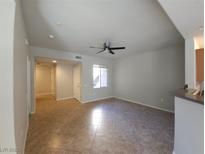 Bright, open living room featuring a ceiling fan and neutral tile flooring at 4675 Basilicata Ln # 103, North Las Vegas, NV 89084
