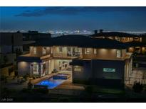 Night shot of a modern two-story home featuring a pool, jacuzzi, and views of the Las Vegas Strip at 5 Crystal Tree Pass, Henderson, NV 89052