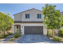 Charming two-story home featuring a paved driveway and inviting curb appeal with mature trees and lovely landscaping at 6938 Feather Hill St, North Las Vegas, NV 89086