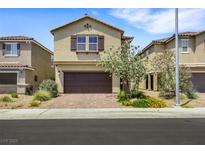 Two story home featuring desert landscaping, a brick driveway, and a two-car garage at 7011 Toll Mountain St, North Las Vegas, NV 89086