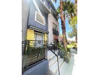 Multi-level home featuring a private front patio, colorful exterior, and desert landscaping at 9050 W Tropicana Ave # 1102, Las Vegas, NV 89147