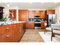 Modern kitchen featuring granite countertops, stainless steel appliances, and wood cabinetry at 9050 W Tropicana Ave # 1102, Las Vegas, NV 89147