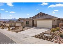Charming single-story home featuring desert landscaping, a tile roof and an attached two-car garage at 942 Shadow Hawk Rdg, Mesquite, NV 89027