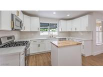 Bright kitchen featuring white cabinets, stainless steel appliances, and a central island at 2107 Fountain Springs Dr, Henderson, NV 89074