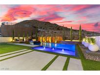 Stunning pool with mountain views, water features, and adjacent spa under a colorful sunset sky at 2601 Nevada Agave Ln, Las Vegas, NV 89138