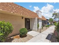 Charming home featuring a striking brick chimney and a welcoming front door and manicured landscaping at 2749 Heritage Cir, Las Vegas, NV 89121