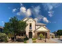 Charming two-story home with a stone facade, balcony, and a well-maintained landscaped front yard at 5128 Blissful Valley Cir, Las Vegas, NV 89149