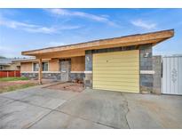 Charming single-story home with a yellow garage door and desert landscaping in front at 54 Del Amo Dr, Las Vegas, NV 89110