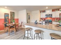 Bright kitchen features an island with bar seating, modern appliances, and a cozy dining area at 6918 Wrightshire St # 24, Las Vegas, NV 89166