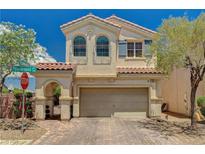 Charming two-story home featuring a tile roof, arched entryway, and well-maintained landscaping at 7486 Benlomond Ave, Las Vegas, NV 89179