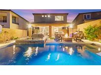 Inviting backyard pool with an outdoor kitchen and lounge area for relaxation and entertaining at twilight at 12430 Foxtail Run Ave, Las Vegas, NV 89138