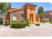 Charming home featuring stone and stucco exterior with a well-manicured front yard and a beautiful brick driveway at 1252 Casa Palermo Cir, Henderson, NV 89011