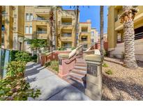 Beautiful condo building exterior with well-maintained landscaping and inviting entryway stairs at 210 E Flamingo Rd # 215, Las Vegas, NV 89169