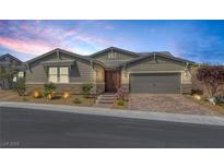 Charming single-story home boasts desert landscaping, a two-car garage and a neutral color palette at 2489 Cingoli St, Henderson, NV 89044