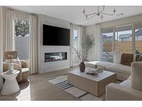 Bright living room featuring a modern fireplace, large TV, stylish decor, and expansive windows for natural light at 2631 Chance Canyon St, Henderson, NV 89044