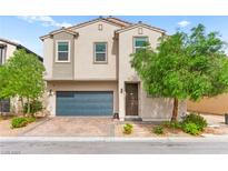 Charming two-story home with desert landscaping and a blue garage door at 2672 Painted Mist Ct, Las Vegas, NV 89142