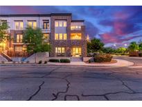 Beautiful multi-story home featuring stone accents, balconies, and manicured landscaping at dusk at 3165 Via Como, Henderson, NV 89044