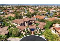 Expansive aerial view of a luxury home with a terracotta roof, lush landscaping, and surrounding neighborhood at 5079 Mountain Top Cir, Las Vegas, NV 89148