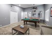 Bright game room features a pool table, neutral paint, ceiling fan, and wood-style tile flooring at 1012 Greystone Dr, Las Vegas, NV 89108