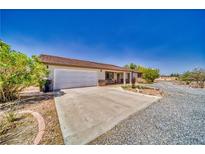 Charming single-story home featuring a two-car garage and desert landscaping at 291 E Hickory St, Pahrump, NV 89048