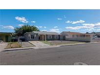 Charming single-story home featuring a gray exterior, a concrete driveway, and low maintenance landscaping at 321 Princess Ave, North Las Vegas, NV 89030