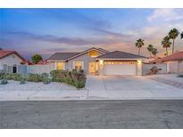 Charming single-story home featuring a two-car garage, desert landscaping, and welcoming curb appeal at twilight at 58 Pleasant Dale Dr, Henderson, NV 89074