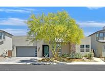 Modern home featuring desert landscaping, two-car garage, and stone accents for enhanced curb appeal at 6834 Fallen Rock St, North Las Vegas, NV 89084