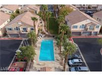 Community pool and palm trees nestled among townhomes with garages and ample parking spaces at 76 Stock Option St # 2, Henderson, NV 89074