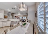 Charming dining area with a modern light fixture and shuttered windows provides great natural light at 76 Stock Option St # 2, Henderson, NV 89074