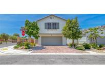 Charming two-story home features a well-manicured yard and a brick-paved driveway leading to an attached garage at 10025 San Floriano St, Las Vegas, NV 89178