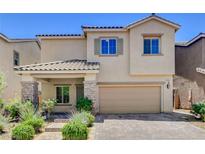 Charming two-story home featuring a stucco exterior, stone accents, and a well-manicured front yard at 1055 Fish Pond Ave, Henderson, NV 89014