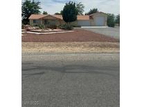 Charming single-story home featuring a terracotta roof, desert landscaping, and an attached two-car garage at 1461 E Elderberry St, Pahrump, NV 89048