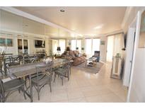 Open-concept living and dining area with neutral decor and large mirrored wall reflecting natural light throughout at 270 E Flamingo Rd # 223, Las Vegas, NV 89169