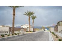 Gated community entrance featuring palm trees and well-maintained landscaping in a desert environment at 2761 Frosted Teal Ave, North Las Vegas, NV 89086