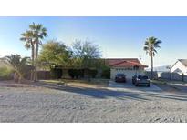 Cozy single-story home featuring a red tile roof, two-car garage, and well-maintained landscaping at 3481 Winery Rd, Pahrump, NV 89048