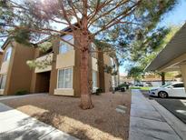 Exterior view of the townhome with gravel landscaping, large windows, and assigned covered parking at 9000 Las Vegas Blvd # 1250, Las Vegas, NV 89123