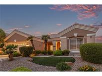 Inviting single-story home with well-manicured landscaping, mature palm trees, and colorful desert sunset at 10832 Heritage Hills Dr, Las Vegas, NV 89134