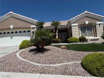 Charming single-story home featuring a well-maintained front yard with desert landscaping, green turf, and mature palm trees at 10832 Heritage Hills Dr, Las Vegas, NV 89134