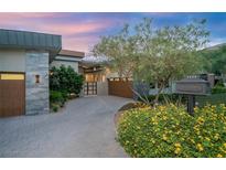Stunning single story exterior with a circular driveway, lush desert landscaping and natural stone accents at 1228 Stellar Rim Ct, Henderson, NV 89012