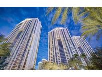 Striking exterior shot of a modern high-rise building with palm trees and blue skies at 135 Harmon Ave # 3220, Las Vegas, NV 89109