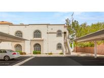 Exterior of condo building with arched windows and assigned covered parking spaces at 3125 N Buffalo Dr # 1103, Las Vegas, NV 89128